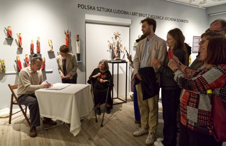 mężczyzna przy stole podpisuje dokumenty